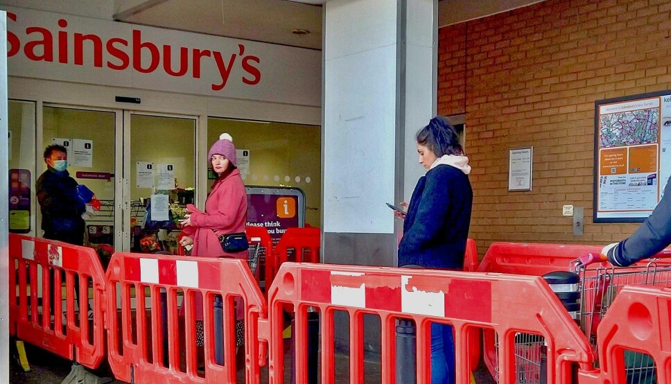Kunder praktiserer sosial distansering utenfor et supermarked i London, mars 2020