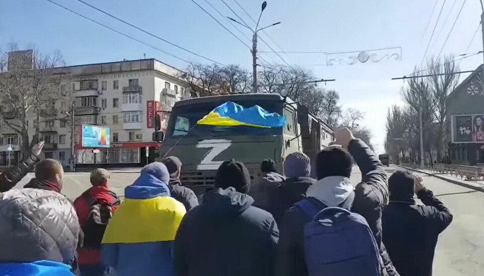 Lokalbefolkningen i Kherson demonstrerer mot russiske militærkjøretøy i mars 2022.