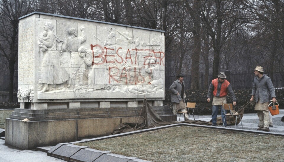 Arbeidere fjerner antisovjetisk graffiti på en av sarkofagene i Treptower-parken i desember 1989.