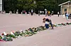 To barn legger ned blomster på slottsplassen.